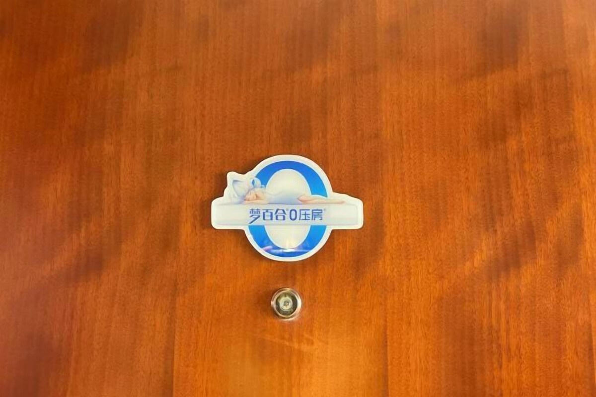 A wooden door with a circular sticker featuring a blue and white design and some text.
