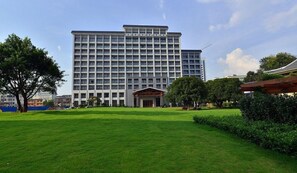A large hotel with a central entrance, surrounded by a well-maintained lawn and trees. - Ji'an Hotel (Ji'an)