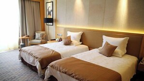 A hotel room with two beds, a chair, a lamp, and a picture on the wall. - Ji'an Hotel (Ji'an)