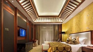 A hotel room with a bed, a TV, a desk, and a chair. - Ji'an Hotel (Ji'an)