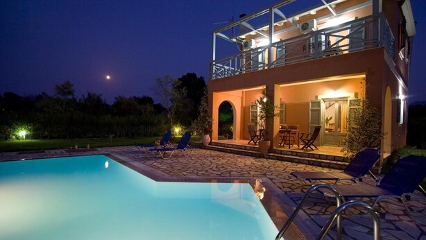 A two-story building with a pool, lounge chairs, and a balcony. - Villa Simeoni Country House with Lake View, Wi-Fi, and Air Conditioning (Lefkada Town)