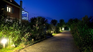 A residential street at night with a house on the left, a lit pathway, and a clear sky. - Villa Simeoni Country House with Lake View, Wi-Fi, and Air Conditioning (Lefkada Town)