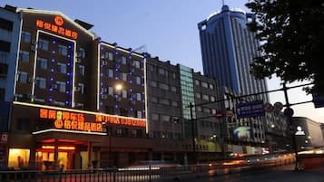A hotel with multiple floors, illuminated windows, and a prominent signboard.