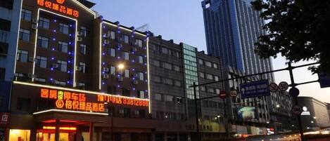 A hotel with multiple floors, illuminated windows, and a prominent signboard.
