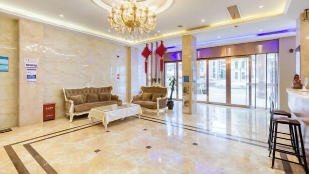 A spacious lobby with a chandelier, two sofas, a coffee table, and a reception desk. - Geyue Zhenpin Hotel (Hangzhou)