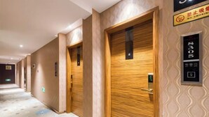 A hotel hallway with wooden doors, numbered room signs, and a no-smoking sign. - Geyue Zhenpin Hotel (Hangzhou)
