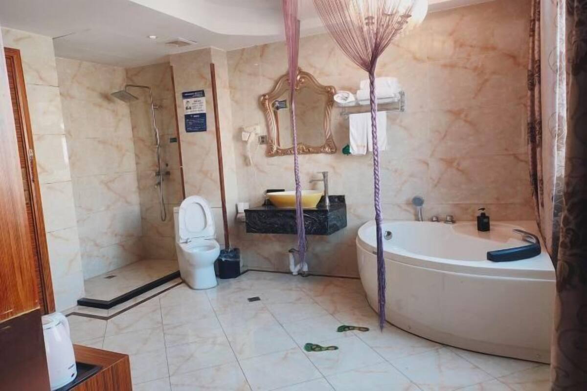 Un bagno completo di doccia, WC, lavandino e vasca da bagno.