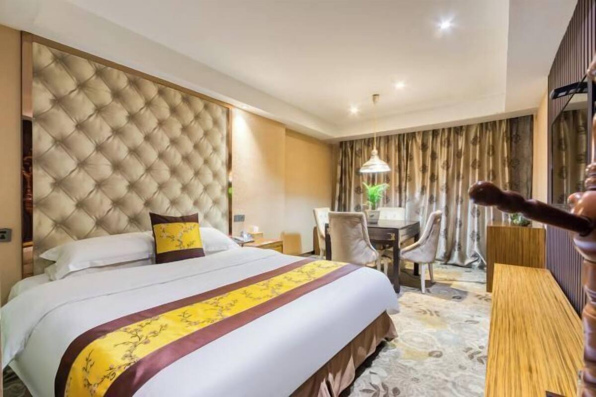 Una camera d'albergo con un letto grande, una scrivania e una sedia.