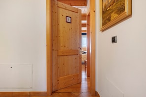 Una puerta de madera con un número, un cuadro enmarcado en la pared y un interruptor de luz.
