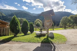 Un cartel con texto, una valla de madera y un paisaje montañoso.