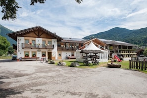 A traditional mountain lodge with a bar, outdoor seating, and a small play area.