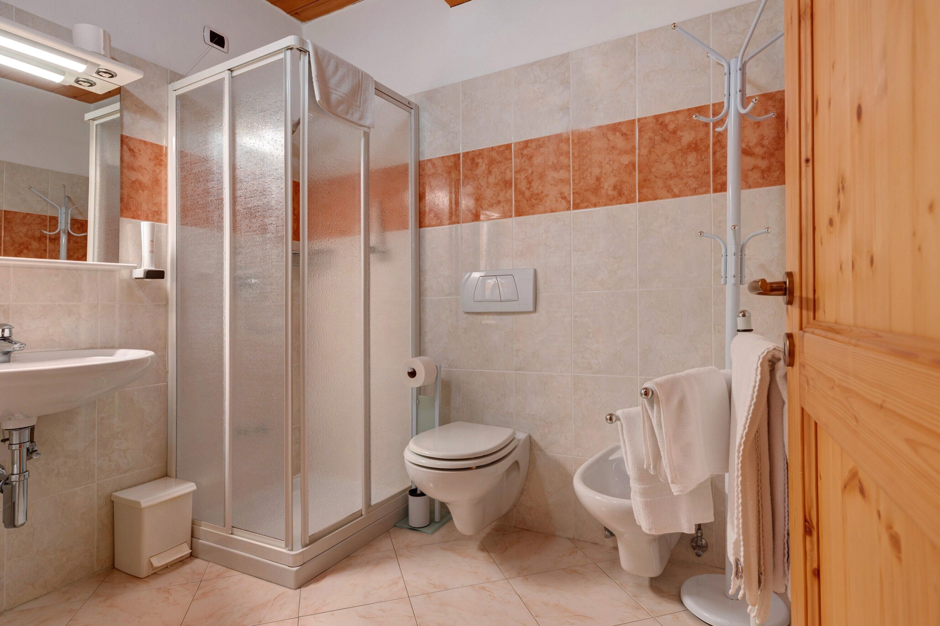 Ein Badezimmer mit Dusche, Toilette, Bidet und Waschbecken.