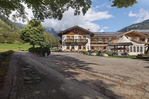 Un chalet de montagne à la façade en bois, doté d’un balcon et offrant une vue sur le paysage environnant.