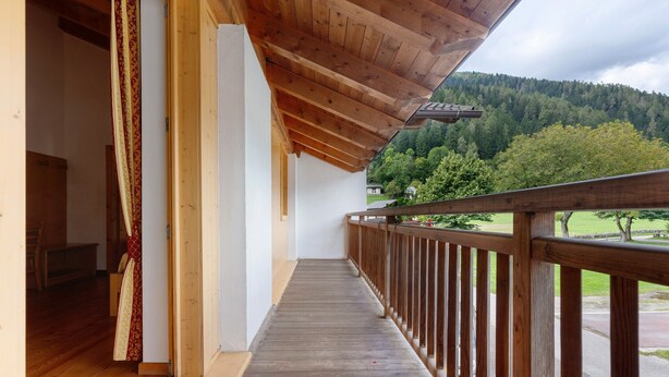 A wooden balcony with a view of a forested hill. - Room 'Camera Tripla N 5' with Mountain View, Shared Garden and Wi-Fi (Caderzone Terme)