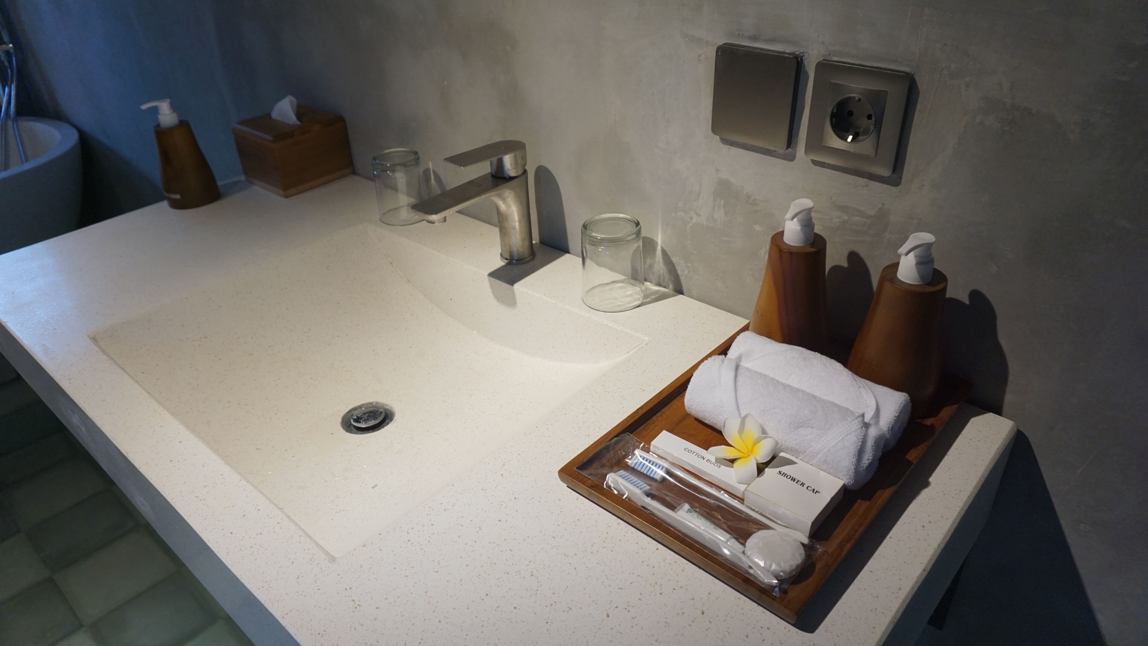 A bathroom with a large sink, a mirror, and toiletries.