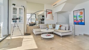 A modern living room with a sofa, coffee table, and a tripod stand.
