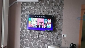 A television mounted on a wall with a decorative pattern. - Wanglong Leisure Hotel (Songbei Harbin University of Commerce, Ice & Snow World) (Harbin)