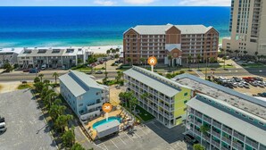 Ein Hotel mit mehreren Etagen, einem Schwimmbad und Blick aufs Meer.