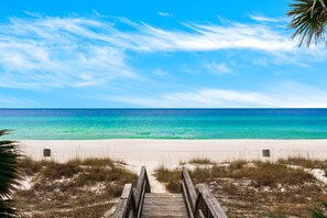 A wooden boardwalk leading to a beach with clear turquoise water and a clear sky. - Stunning Beach Retreat in PCB with Free Parking & 1 Minute Walk To The Beach! $300 Free Fun Daily! (Panama City Beach)