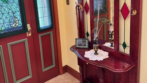Una puerta de madera con paneles de vidrio decorativo y un cartel de bienvenida.
