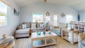 A spacious living room with a beige sofa, patterned armchairs, a wooden coffee table, and a ceiling fan. - Pet Friendly, Golf Cart Access, Boat Parking (Port Aransas)