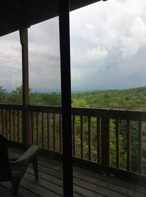 A wooden deck with a view of a forested landscape. - Winterplace D105 Ski in Ski out condo First Floor (Ghent)