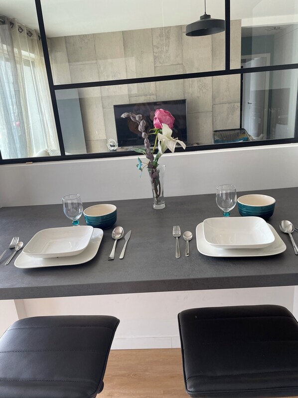 A modern kitchen with a dining area set for two.