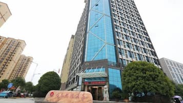 A tall, modern building with a glass facade and a prominent entrance.