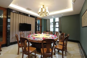 Un coin repas avec une table ronde, des chaises et un lustre.
