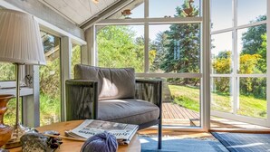 A cozy room with a large window, a comfortable chair, a table with a newspaper, and a lamp. - "Palle" - 400m from the sea by Interhome (Ebeltoft)
