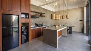 Una cocina moderna con armarios de madera, una isla central e iluminación colgante.