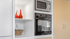 A kitchen with a microwave, oven, and wooden cabinets. - "Kalli" - 100m from the sea by Interhome (Sydals)