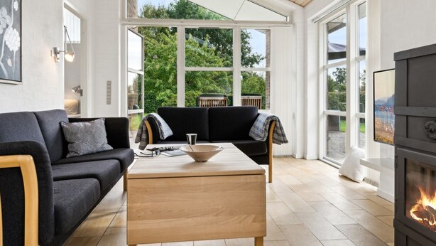 A modern living room with a sofa, coffee table, and fireplace.