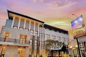 A hotel with multiple floors, a balcony on the ground floor, and a large signboard. - Grand Malioboro Yogyakarta Hotel (Gedong Tengen)