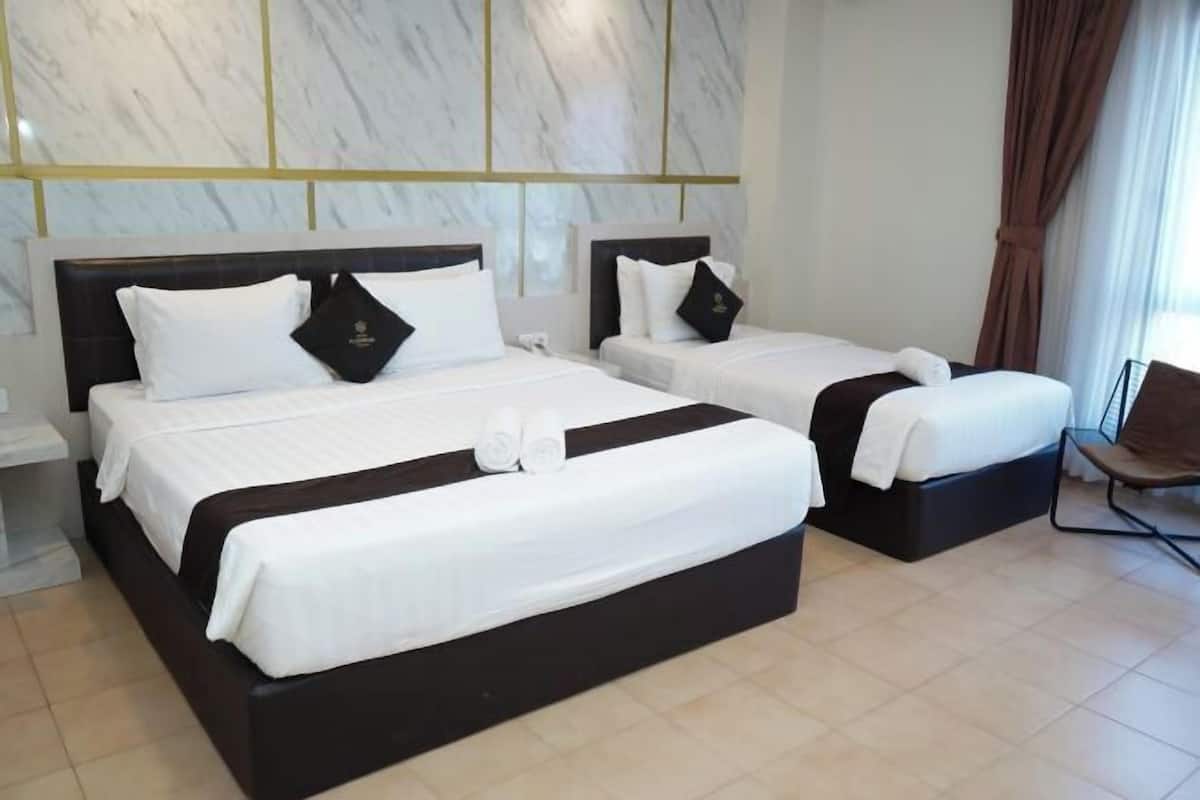 Ein Hotelzimmer mit zwei Betten, Marmorvertäfelung, einem Sessel und einem Fenster mit Vorhängen.