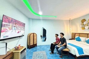 Une chambre d’hôtel comprenant un lit, un téléviseur et un coin salon.