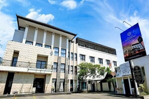 Un bâtiment à la façade en pierre, doté de nombreuses fenêtres, et un ciel dégagé.