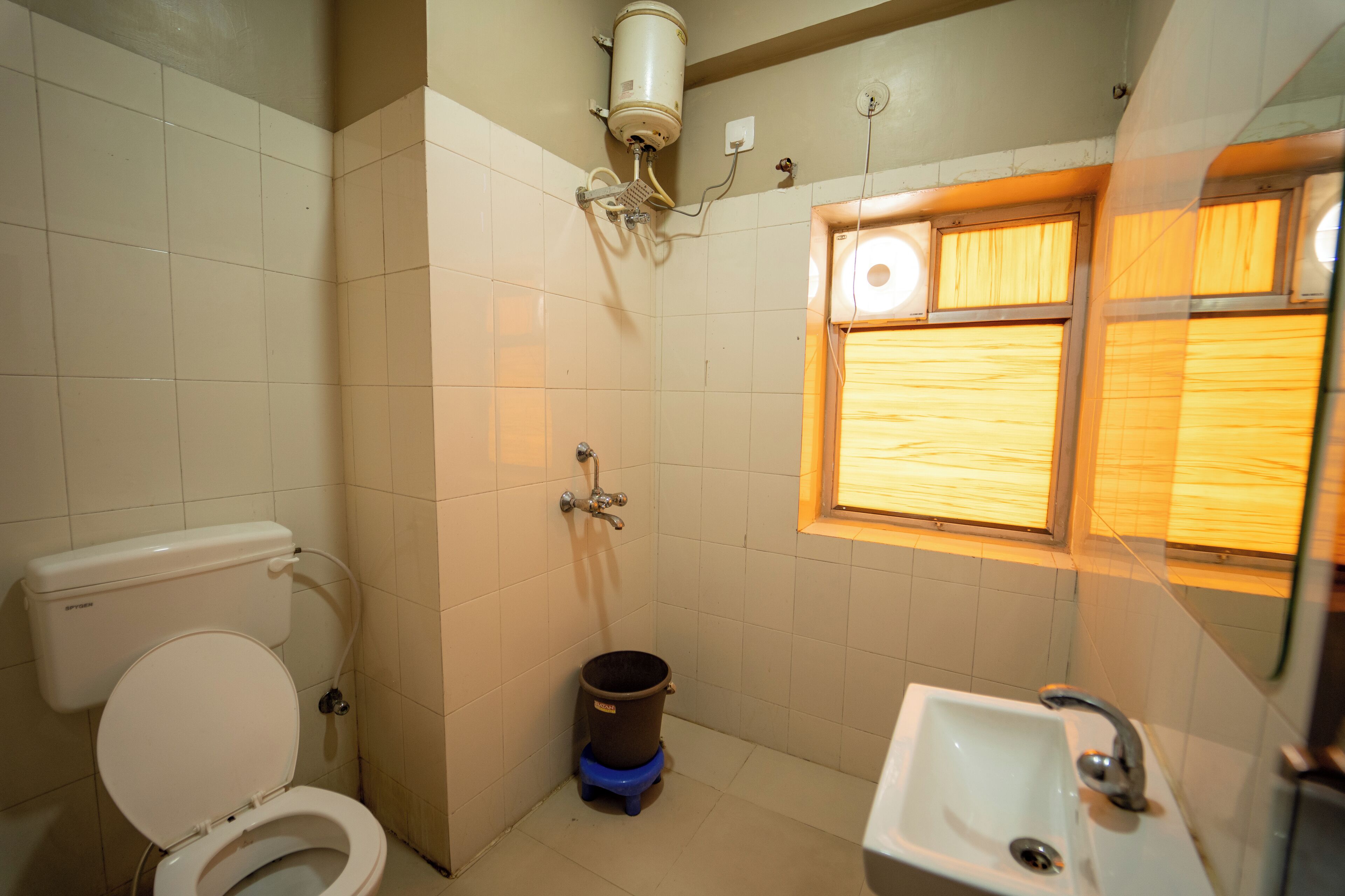 A small bathroom with a toilet, a sink, and a window.