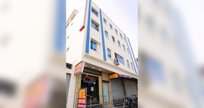 Un edificio de hotel de varios pisos con un letrero que indica 'HOTEL SUDUIMANIA' y una persiana baja en la planta baja.