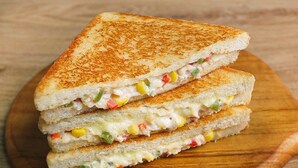 A grilled sandwich with visible ingredients like corn and green peppers.