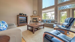 A spacious living room with a fireplace, a television, and comfortable seating.