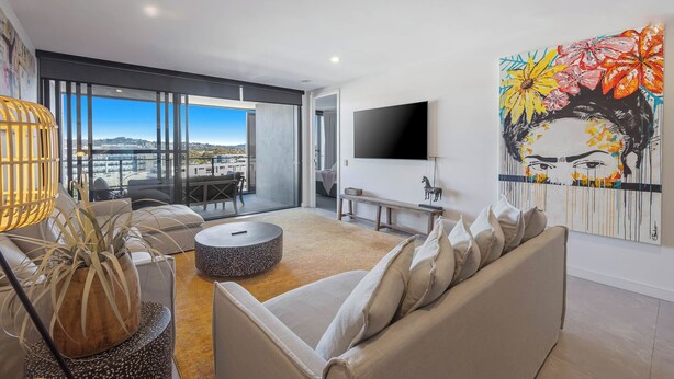 Ein modernes Wohnzimmer mit Sofa, Couchtisch und einem Bild an der Wand.