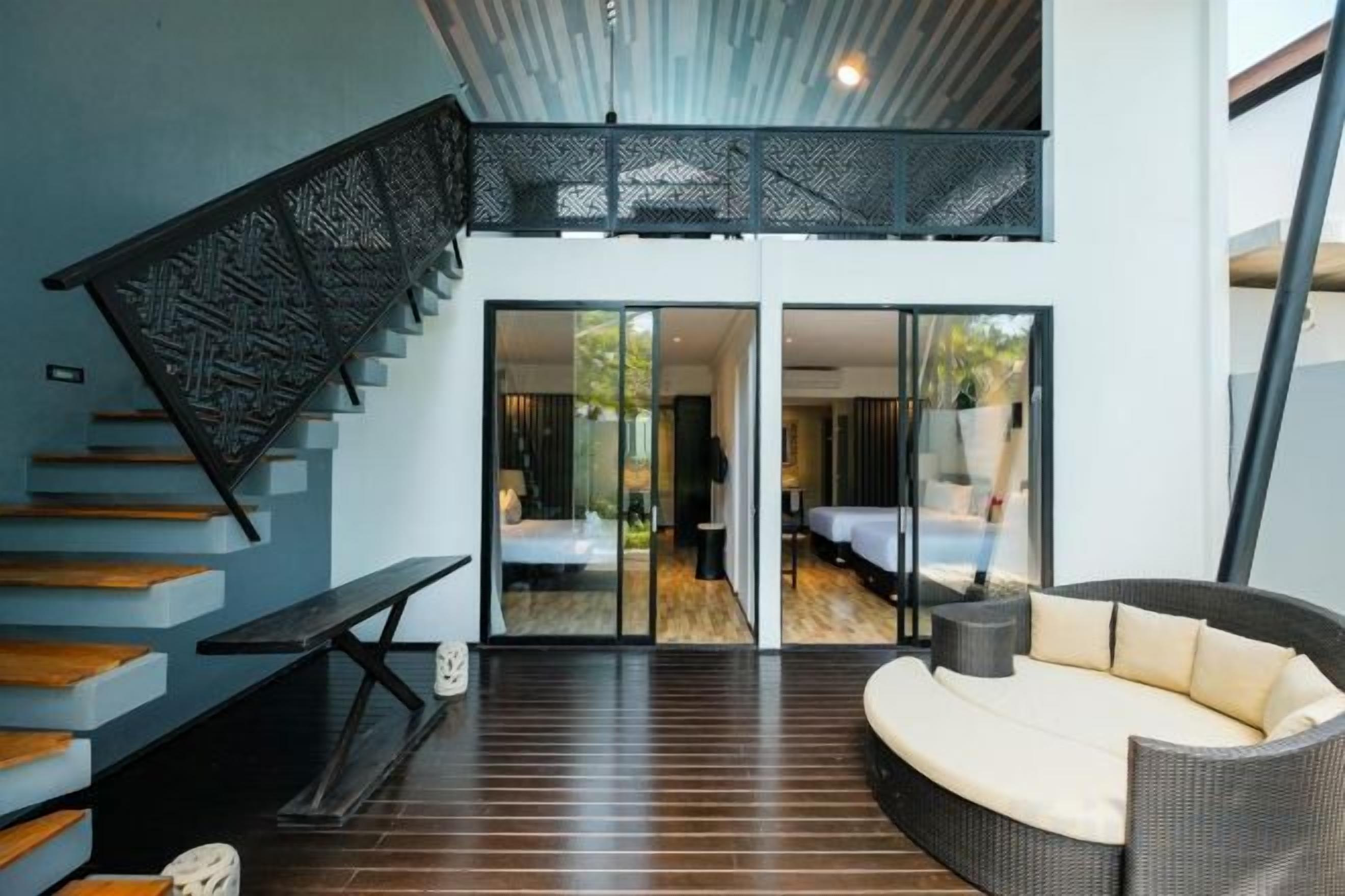 A modern interior with a staircase, a sofa, and a dining table.