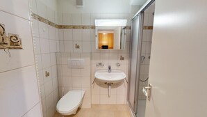 A small bathroom with a toilet, sink, and mirror. - Well-kept holiday apartament house in a prime location in St. (St. Moritz)
