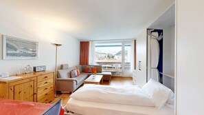 Une chambre d’hôtel avec un lit, un canapé, un bureau et une vue sur l’extérieur.