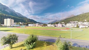 A sports field with a running track, surrounded by buildings and mountains. - Well-kept holiday apartament house in a prime location in St. (St. Moritz)