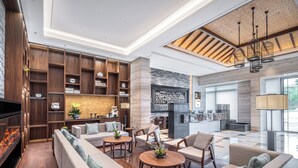Un salón amplio con chimenea, estanterías de madera y asientos cómodos.