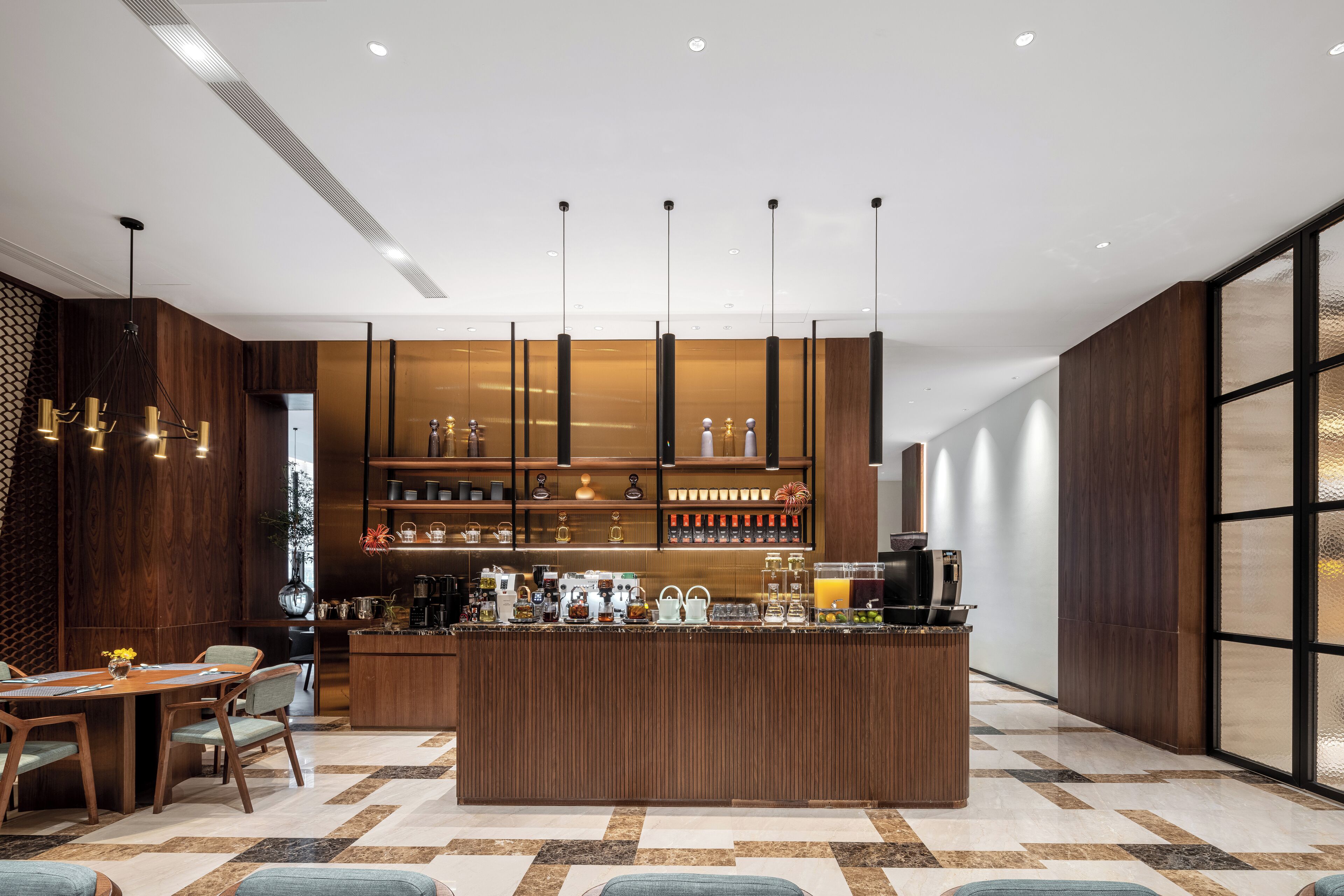 A modern kitchen with a central island, wooden cabinets, and a bar area with various appliances and glassware.