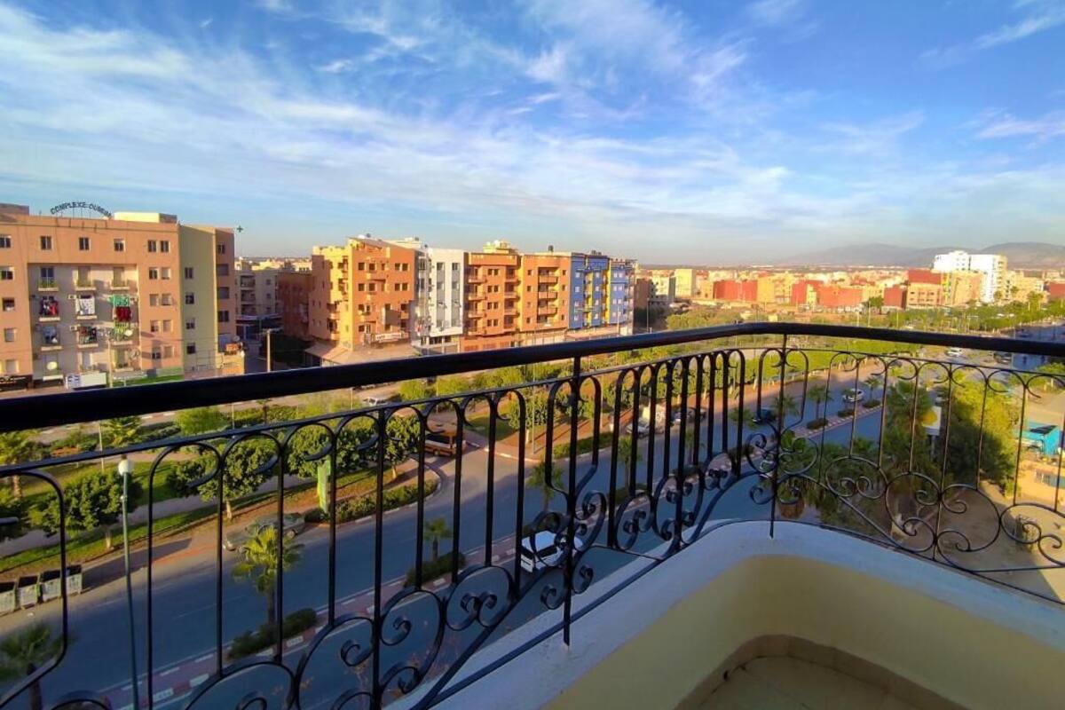A balcony with a view of a cityscape, including buildings and a road.