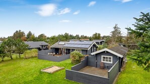 Un quartier résidentiel composé de plusieurs maisons, chacune dotée d’une terrasse et d’un petit jardin.